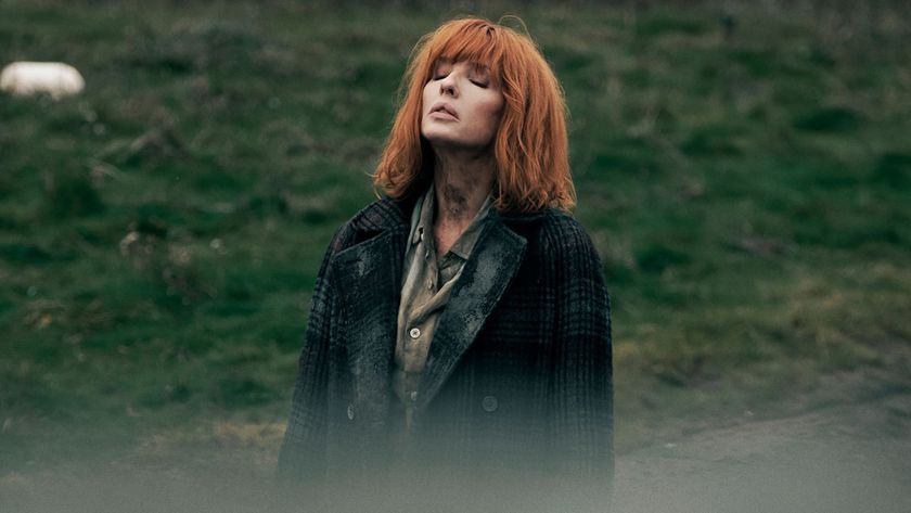Kelly Reilly stands in a field with her eyes closed