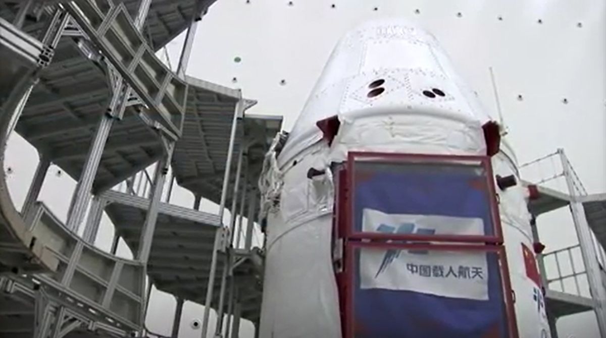 China's next-generation space capsule for astronauts is prepared for its uncrewed test flight on a Long March 5B rocket in these stills from a CCTV state news video. The capsule launched May 5, 2020.