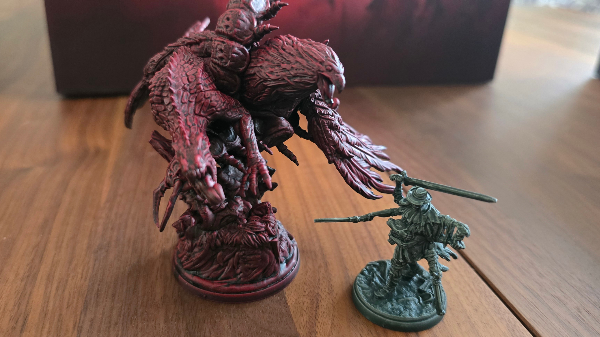 A multi-headed monster miniature beside a multi-armed model in Victorian clothing