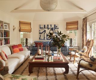 neutral conservatory living room with large patio doors and a range of seating with bamboo blinds