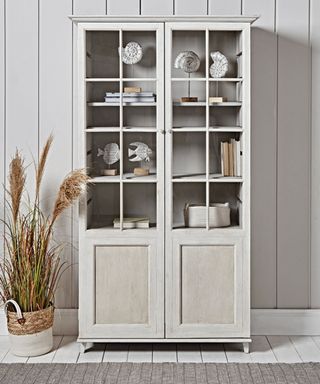 How to style a display cabinet - neutral glass fronted wooden dresser with nautical accessories and white tongue and groove walling