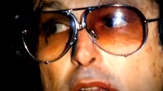 A closeup of Robert Evans wearing sunglasses