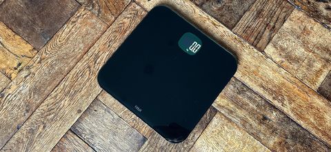 The Fitbit Aria Air smart scale on wooden floor