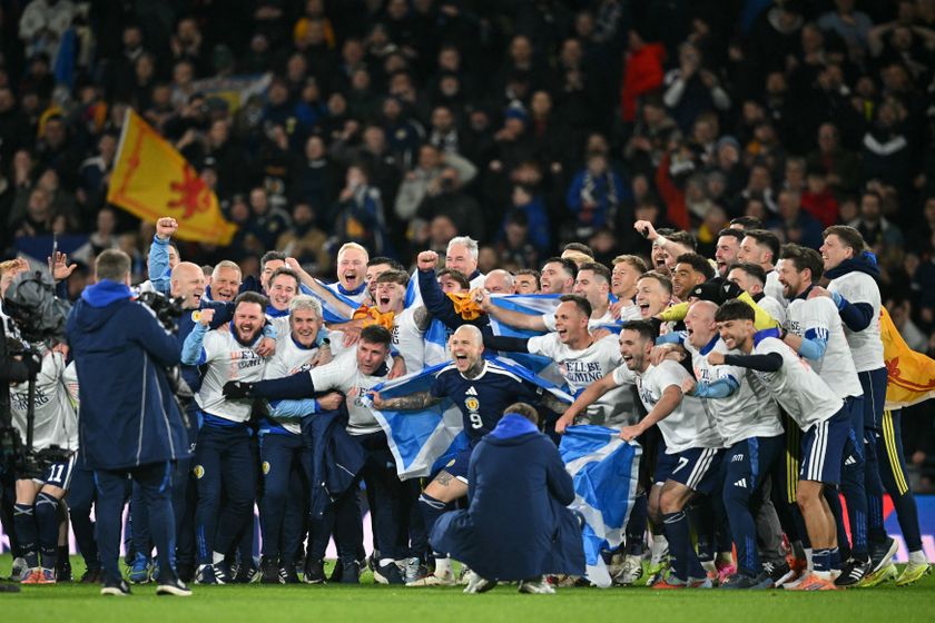 Scotland players celebrate on the pitch after the FIFA World Cup 2026 European qualification football match between Scotland and Denmark at Hampden Park in Glasgow on November 18, 2025. Scotland scored two dramatic stoppage-time goals to beat 10-man Denmark 4-2 on Tuesday and reach the World Cup for the first time since 1998. (Photo by ANDY BUCHANAN / AFP)