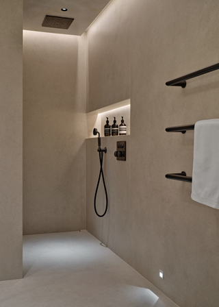 A sleek modern grey concrete bathroom with hidden LED lighting