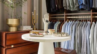 a walk in closet with items on display on a table