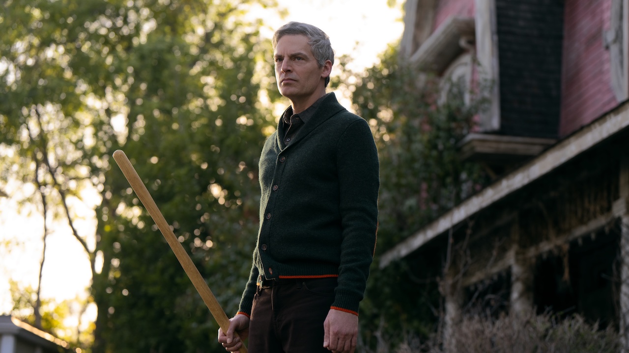 Justin Kirk holding bat in Peacock&#039;s The Burbs series