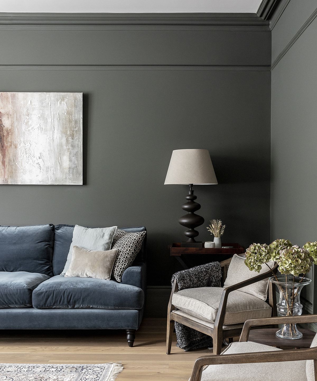 Charcoal grey living room walls with a denim-blue velvet sofa and armchairs