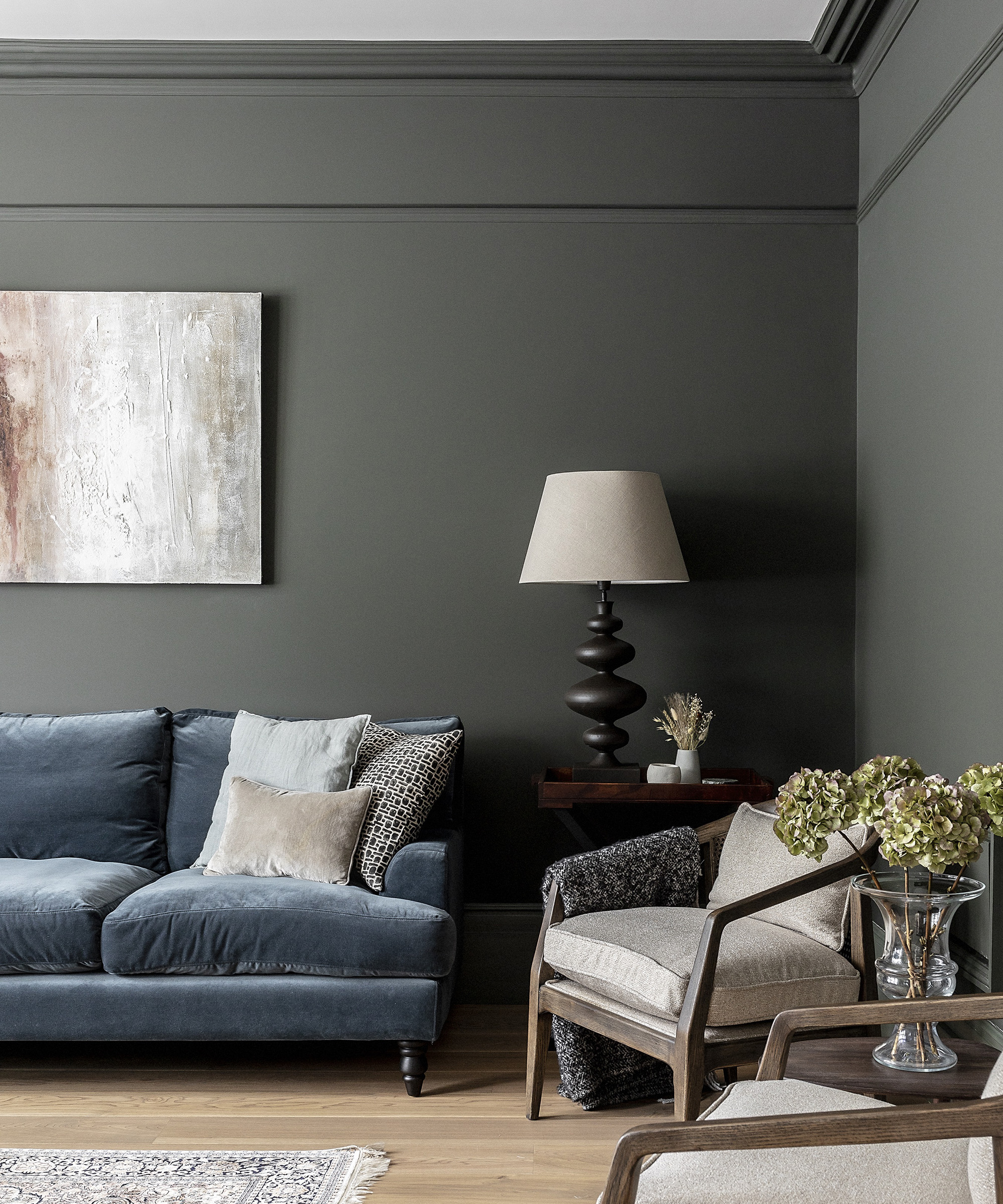 Charcoal grey living room walls with a denim-blue velvet sofa and armchairs