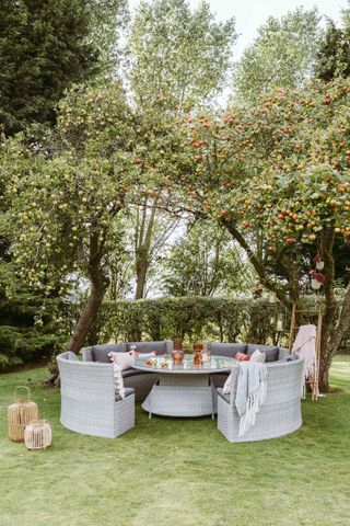 round sofa under apple trees