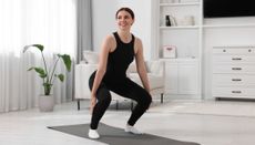 Woman squatting in living room