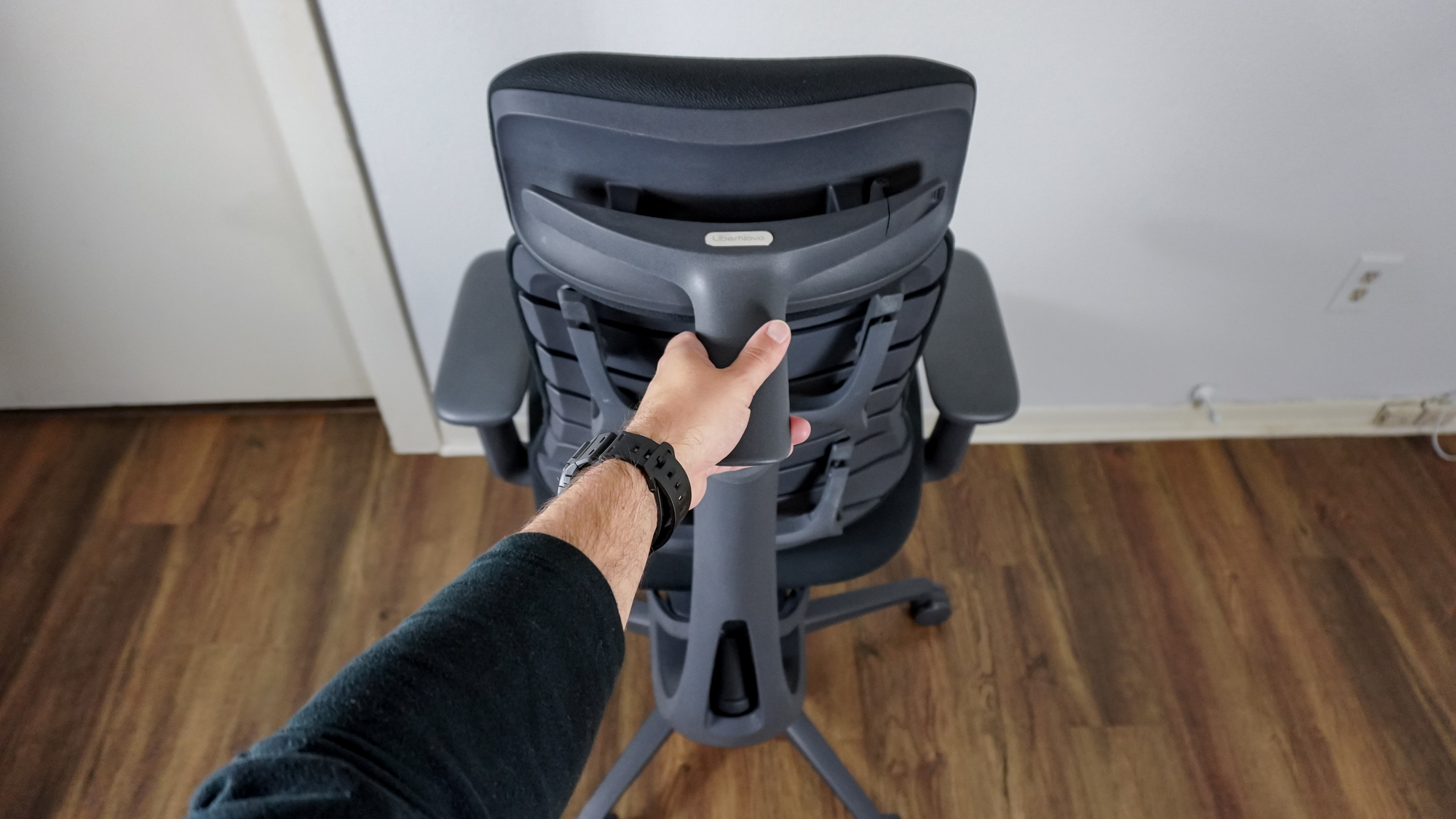 A person using the handle on the back of the LiberNovo Omni's headrest to spin the chair around