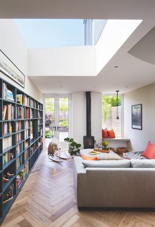 modern living room with large roof lights and bookcase
