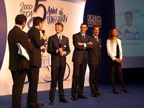 Fassa team manager Giancarlo Ferretti's favourite Volodomir Gustov enjoys a joke with presenter Fabrizio Frizzi. (L-R: Davide Cassani, Frizzi, Gustov, Roberto Petito, Matteo Tosatto and Miss Veneto)