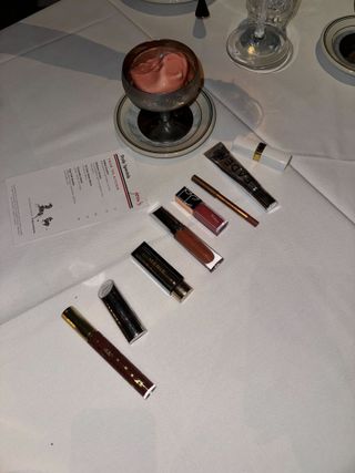 a photo of various lip glosses at a dinner table at Jean's in NYC