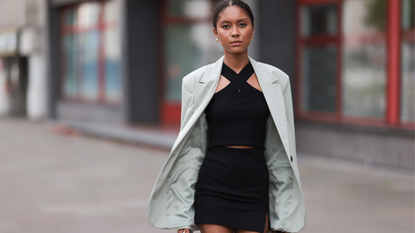 Annabelle Müller seen wearing gold earrings, brown tortoise sunglasses, black knit tank top, white cream blazer jacket, black short skirt, on August 25, 2023 in Hamburg, Germany.