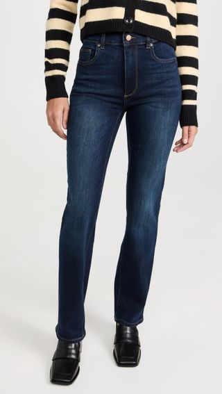 a model wears dark-wash blue jeans with a straight leg