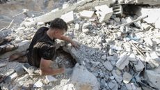 A man searches through rubble in Gaza
