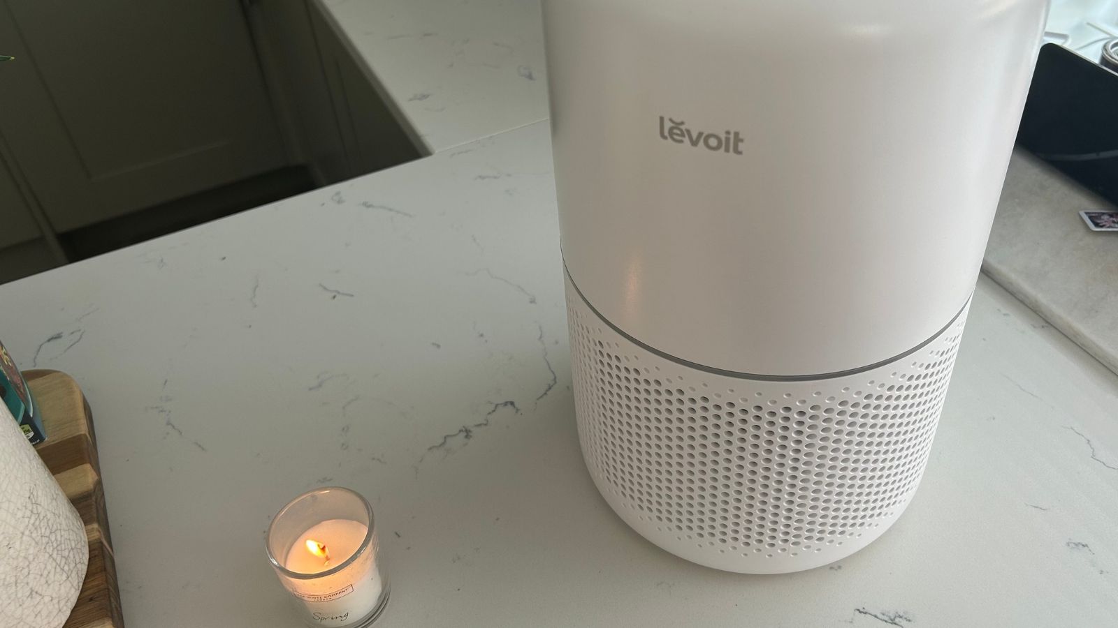 Levoit air purifier on kitchen island with votive candle lit next to it