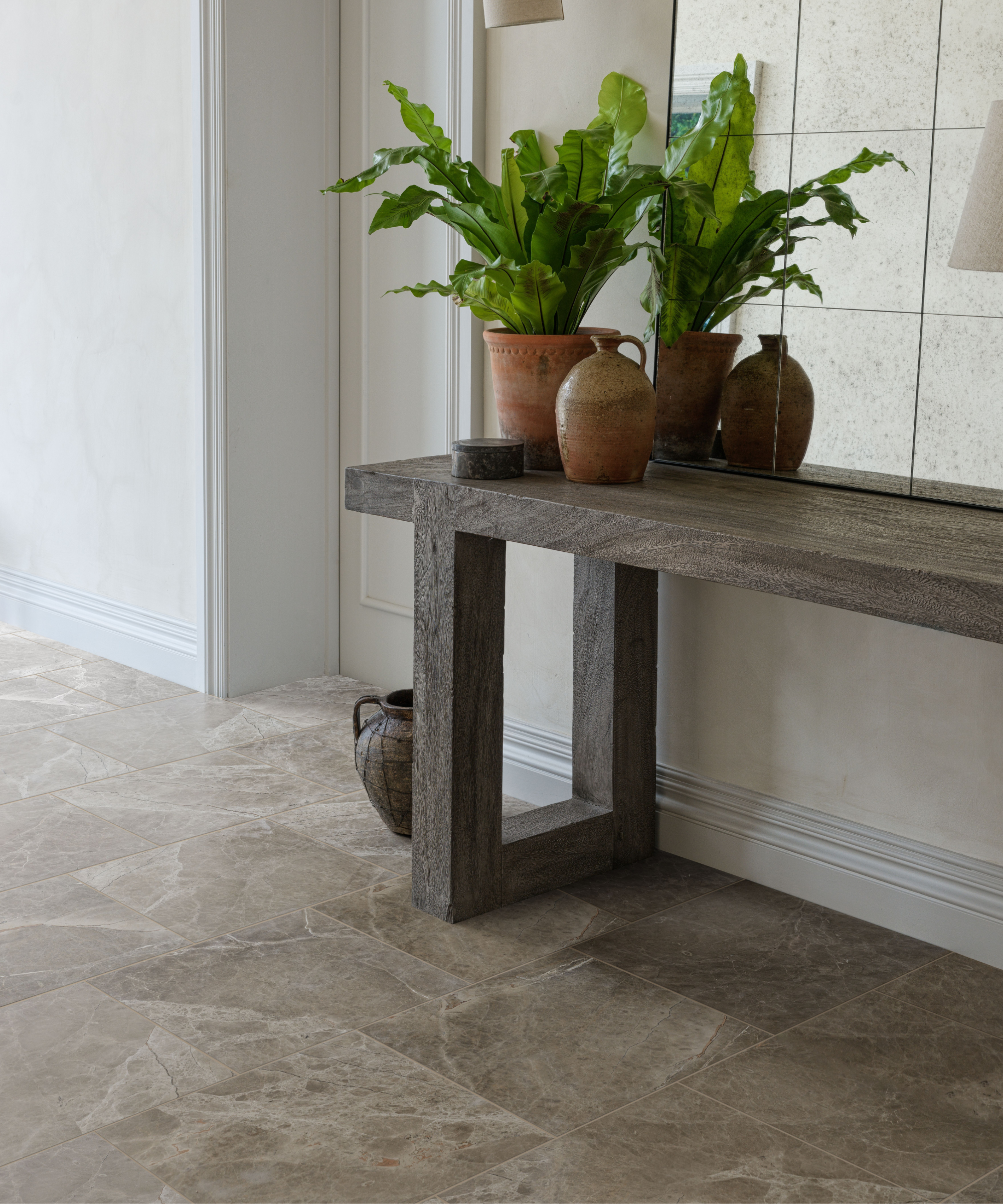 Hallway with marble style flooring and a bench with plant pot on it