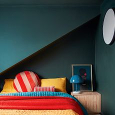 Teal bedroom with brightly coloured bedding