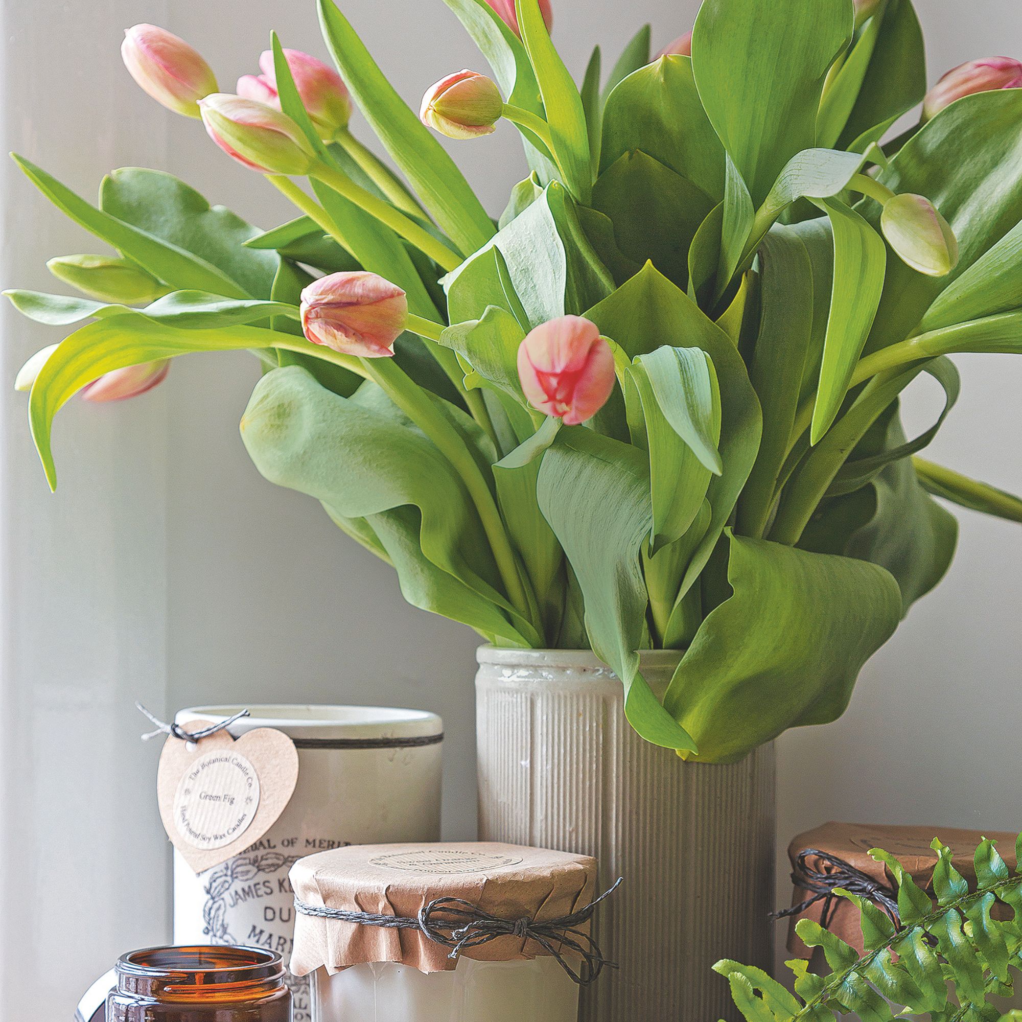 A fresh bouquet of tulips in a beige vase