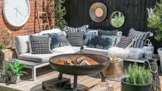 outdoor living space ideas with large fire pit and sofa on deck