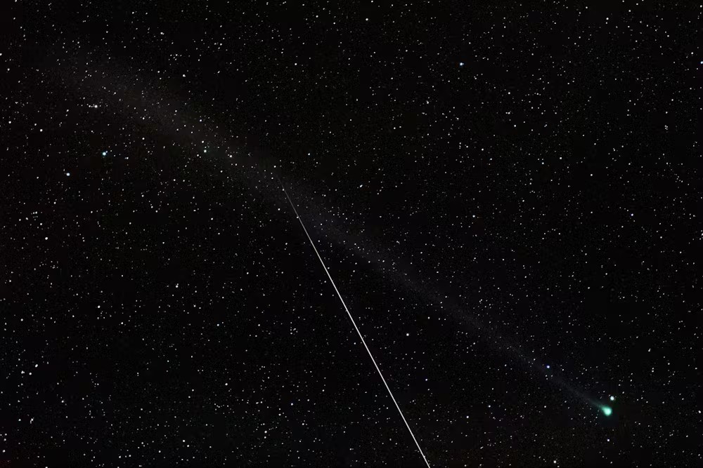 a green streak of light zooms among the stars