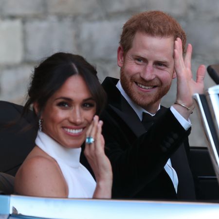 Prince Harry and Meghan Markle wave from a blue car on their wedding day