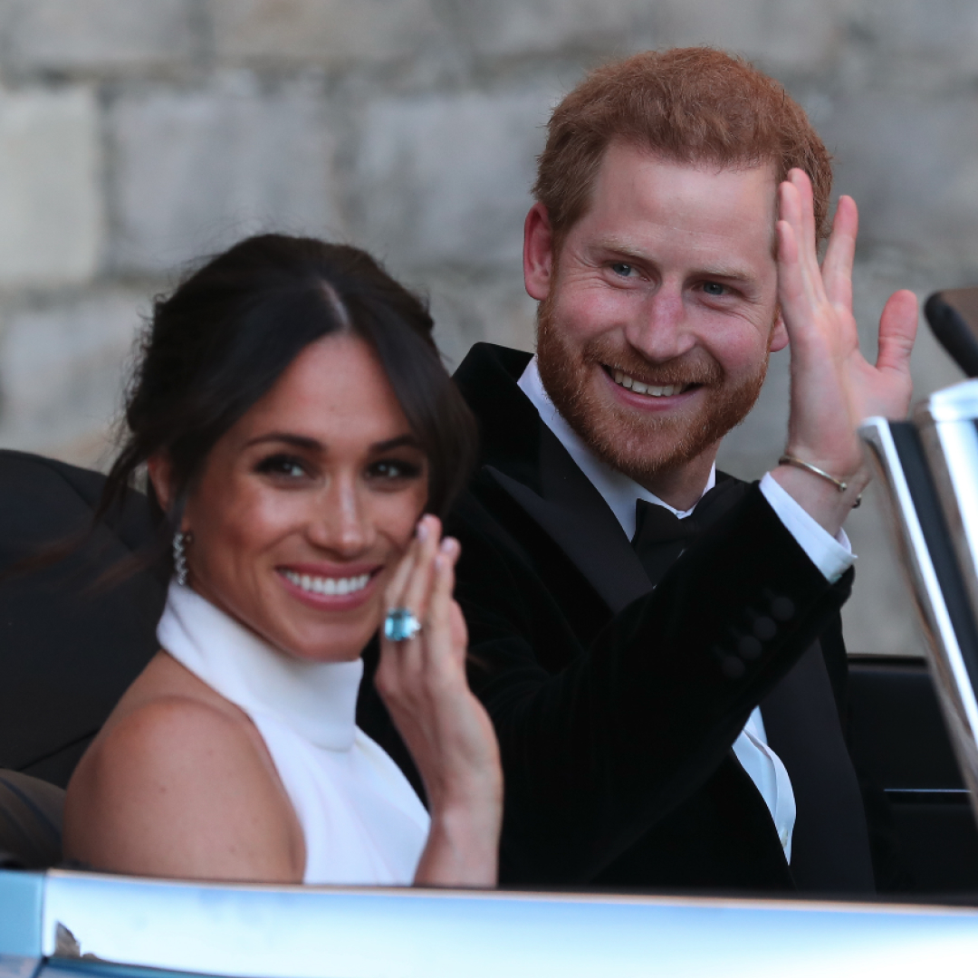 Prince Harry and Meghan Markle wave from a blue car on their wedding day