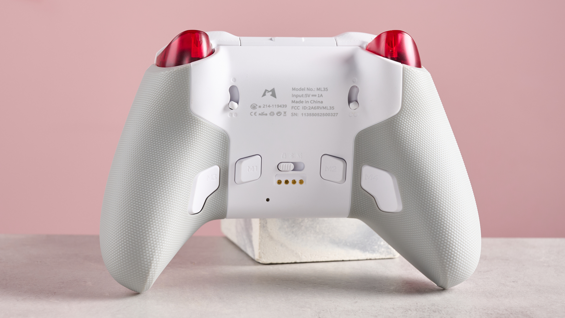 Rear of Mobapad Huben 2, leaning on plinth on desk with pink background