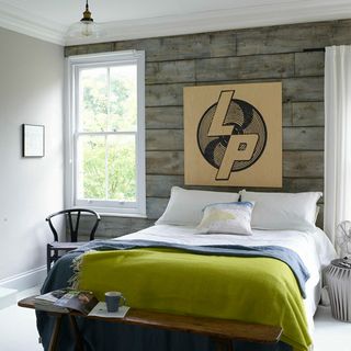 bedroom with wooden wall white window bed with cushion and blanket