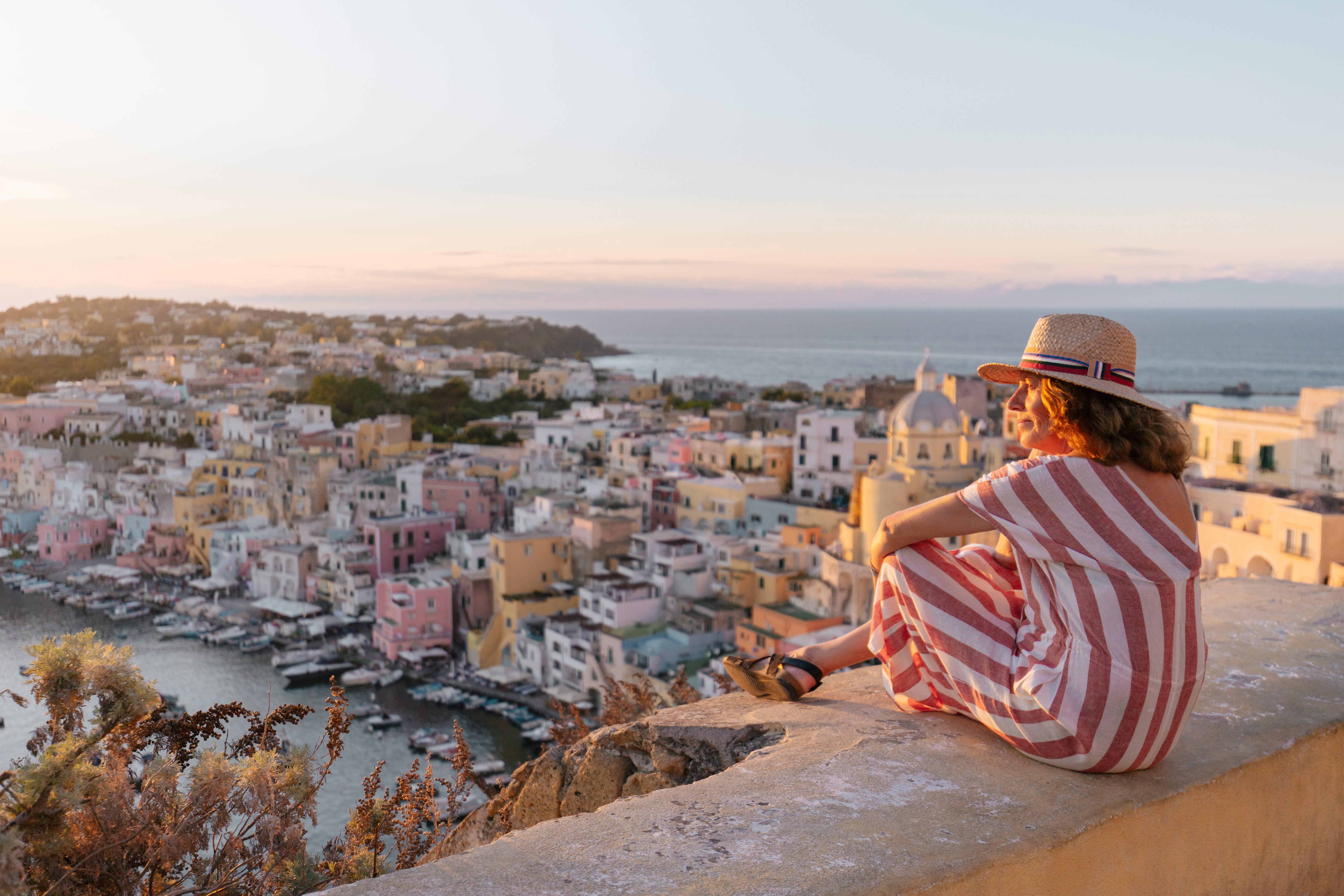 A woman admiring a sunset cityscape.