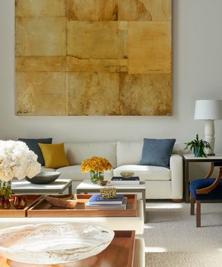 modern organic living space with large cream sofa and a statement piece of ochre wall art