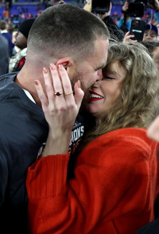 Taylor Swift and Travis Kelce kiss on the field at the 2024 AFC Championship