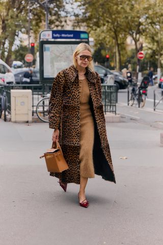 Showgoer at Paris Fashion Week wearing a leopard print coat.