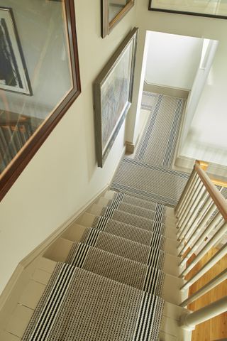 Staircase from above with runner on floor and mirrors on the wall