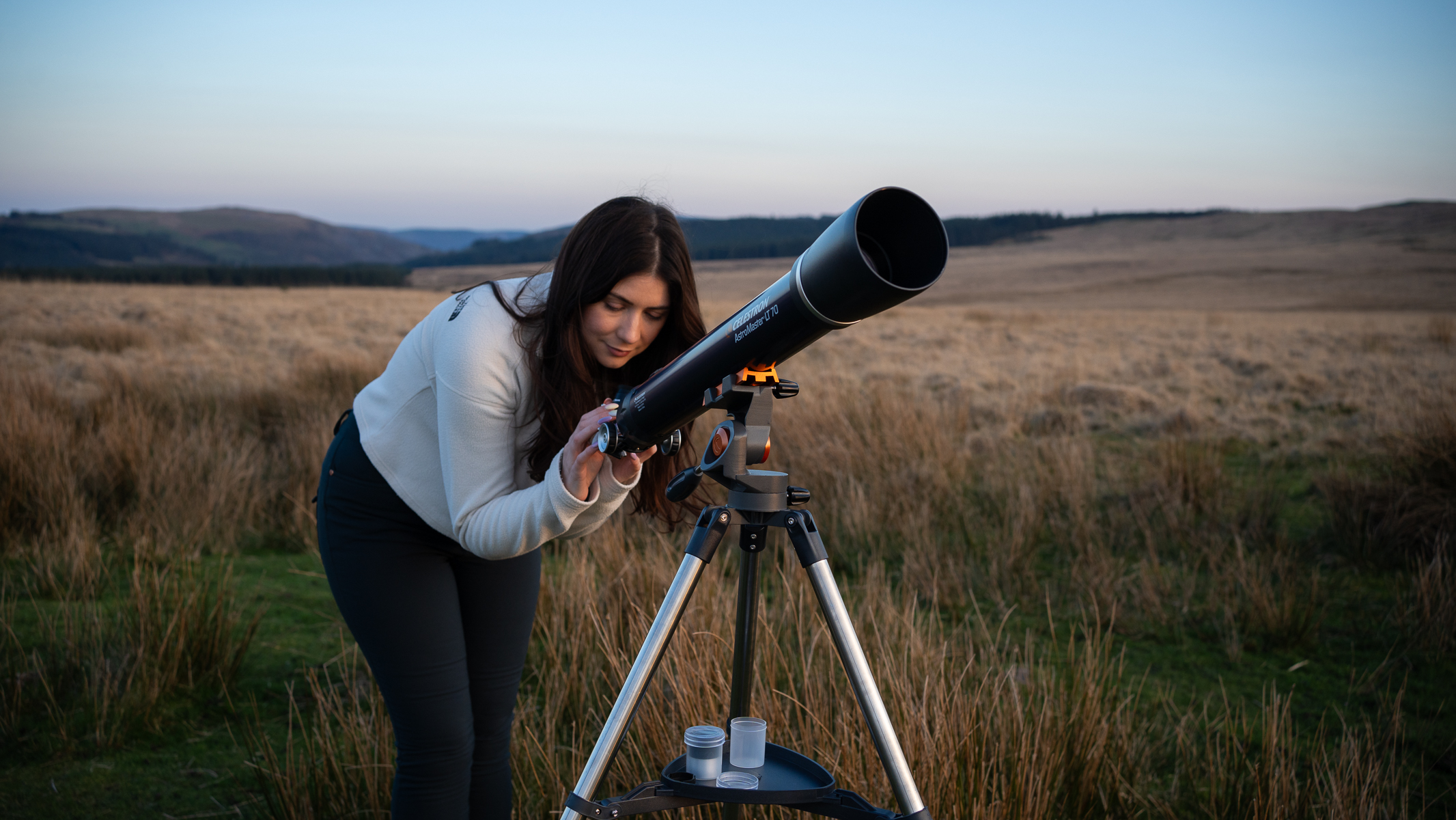 woman using the Celestron AstroMaster LT 70AZ in a field