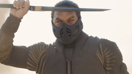 Duncan in a stillsuit and mask, saluting with a blade in the Dune 3 trailer.