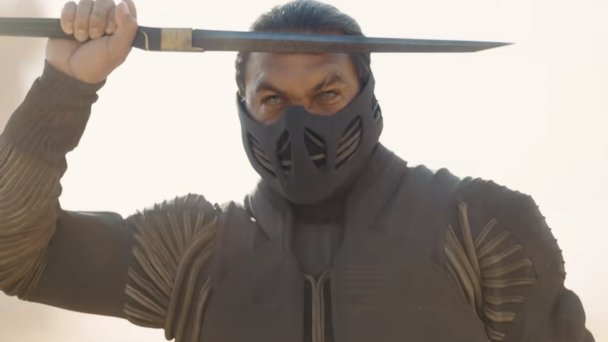 Duncan in a stillsuit and mask, saluting with a blade in the Dune 3 trailer.