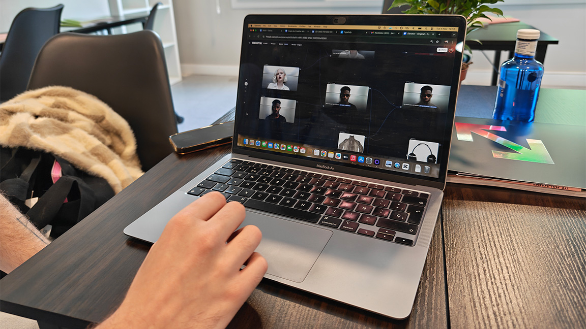 A person uses a computer running Freepik Spaces