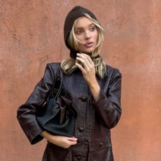 Elsa Hosk wearing a burgundy croc jacket with plane pants and flat loafers