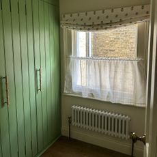 Green laundry room with laundry racks in cupboard