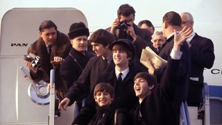 The Beatles disembark a plane in a still from Disney Plus' "Beatles '64"