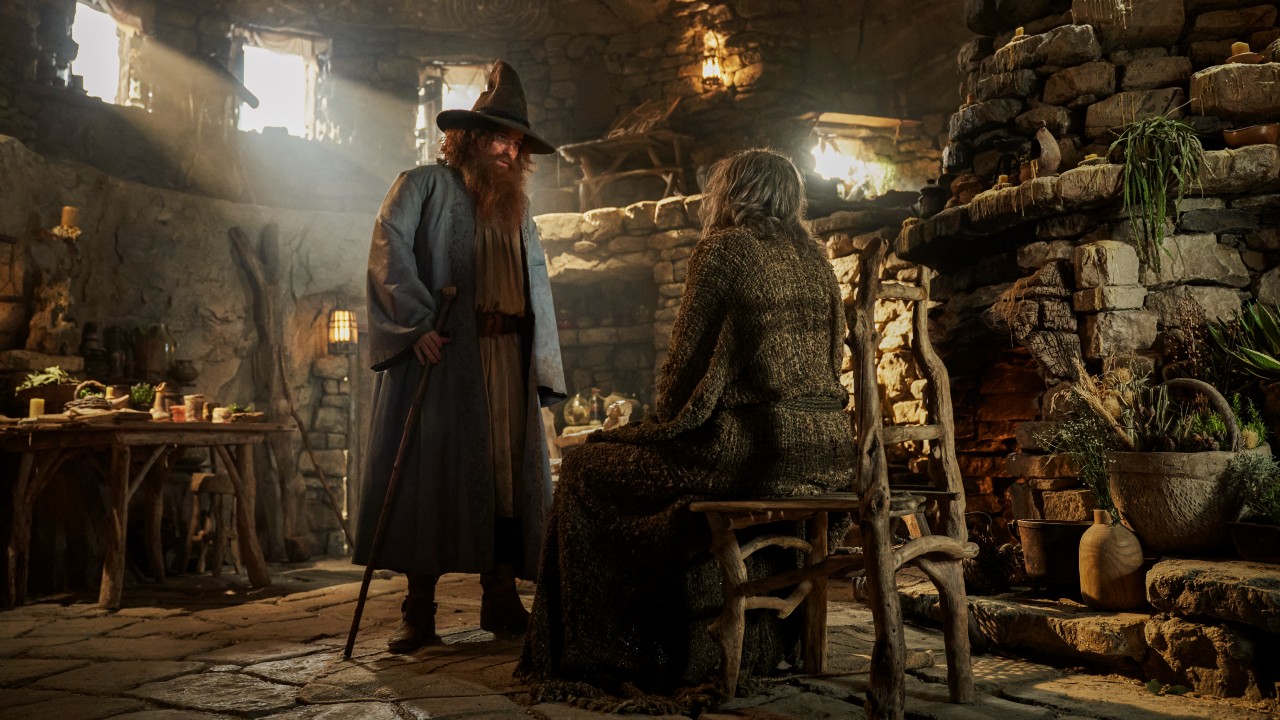 Rory Kinnear as “Tom Bombadil” talking to Daniel Weyman as “The Stranger”.