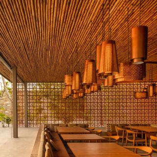 Patina Maldives restaurant with hanging grass lampshades and wooden ceiling