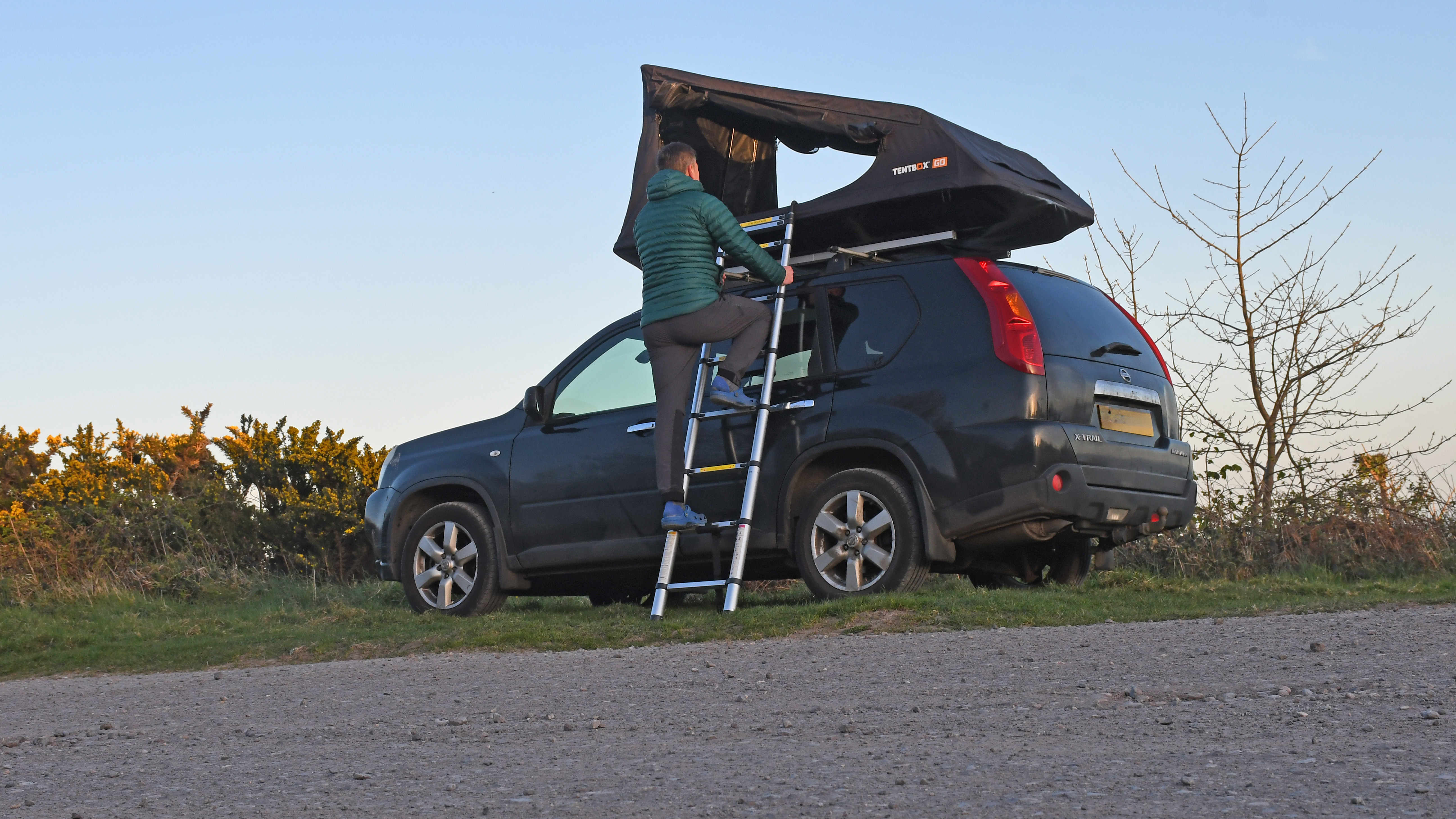 A man climbs the ladder to access the TentBox Go