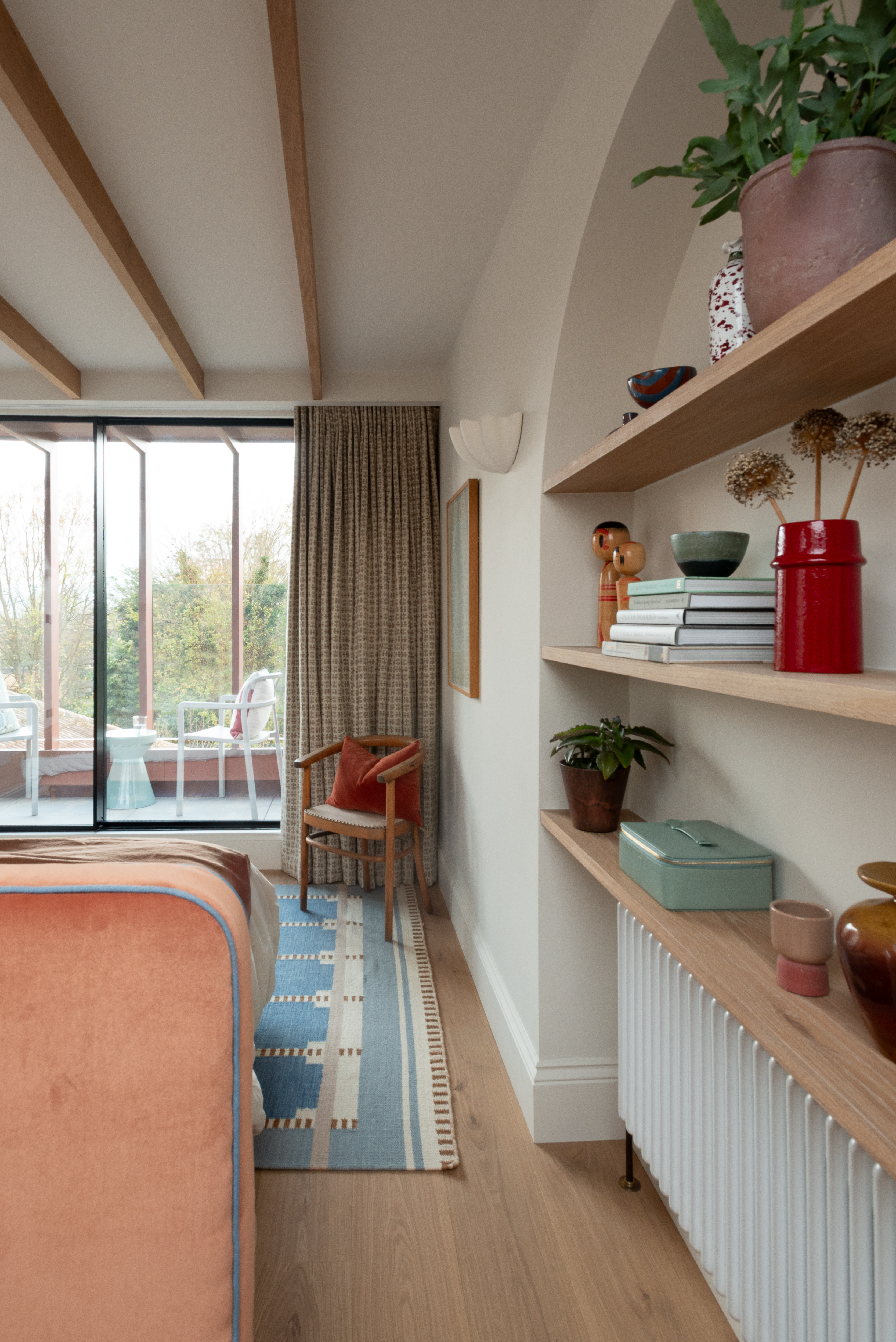 loft conversion bedroom with wooden shelves built into an arched alcove