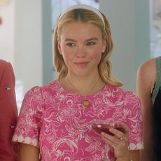 a close up of Milly Alcock wearing a nantucket basket necklace