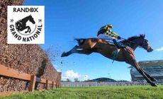 Aintree logo placed over a horse rider hurdling a fence